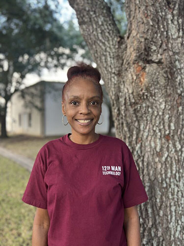 One lady outside by a tree wearing12th Man Technology shirt.