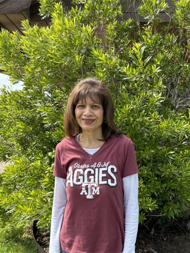 One lady outside by a bush wearing12th Man Technology shirt.